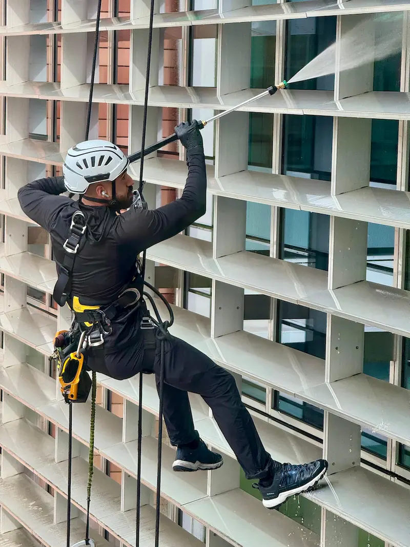 abseiling with water fed pole to clean glass building and facade railing